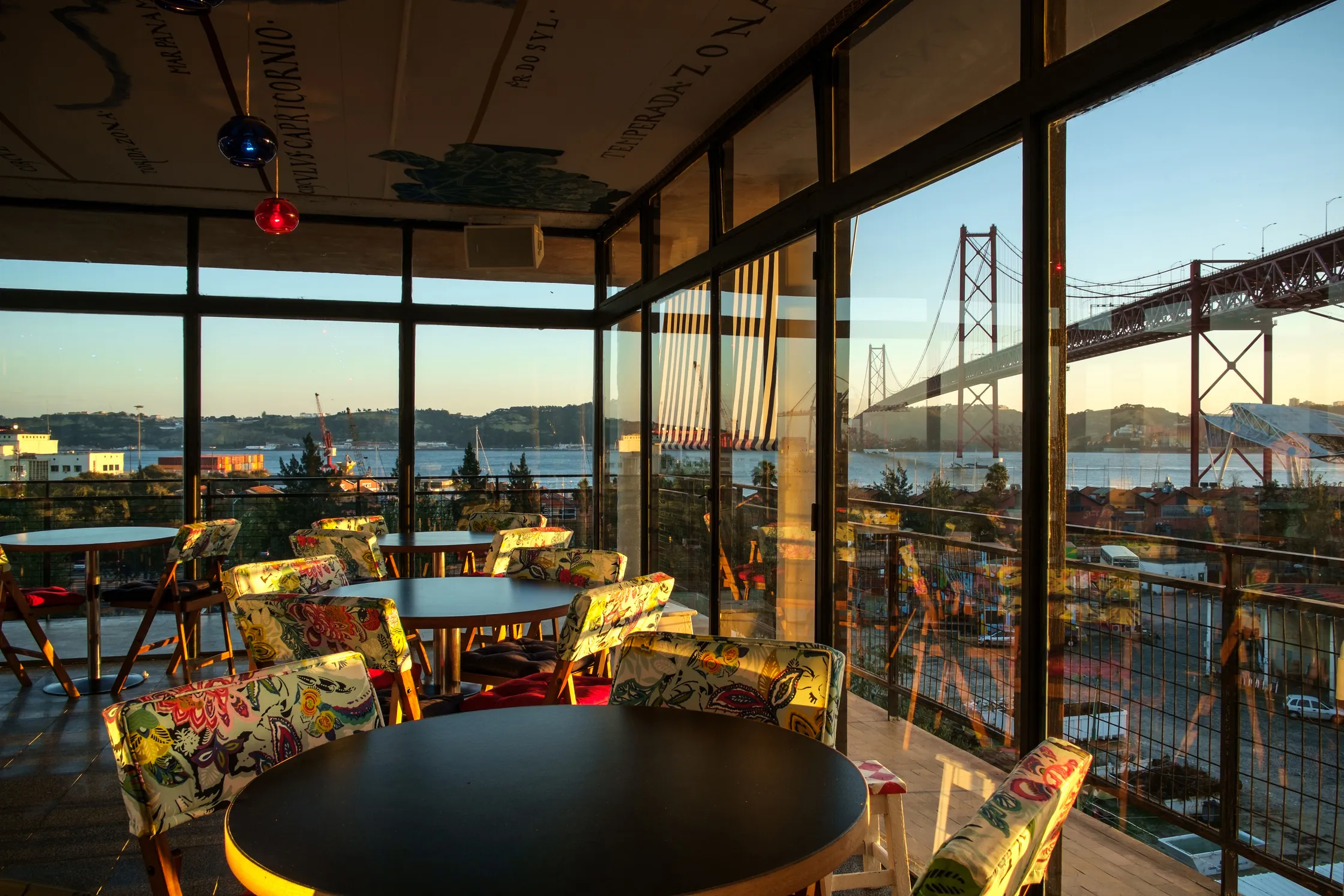 sunset lighting a room on the rooftop with chairs and tables