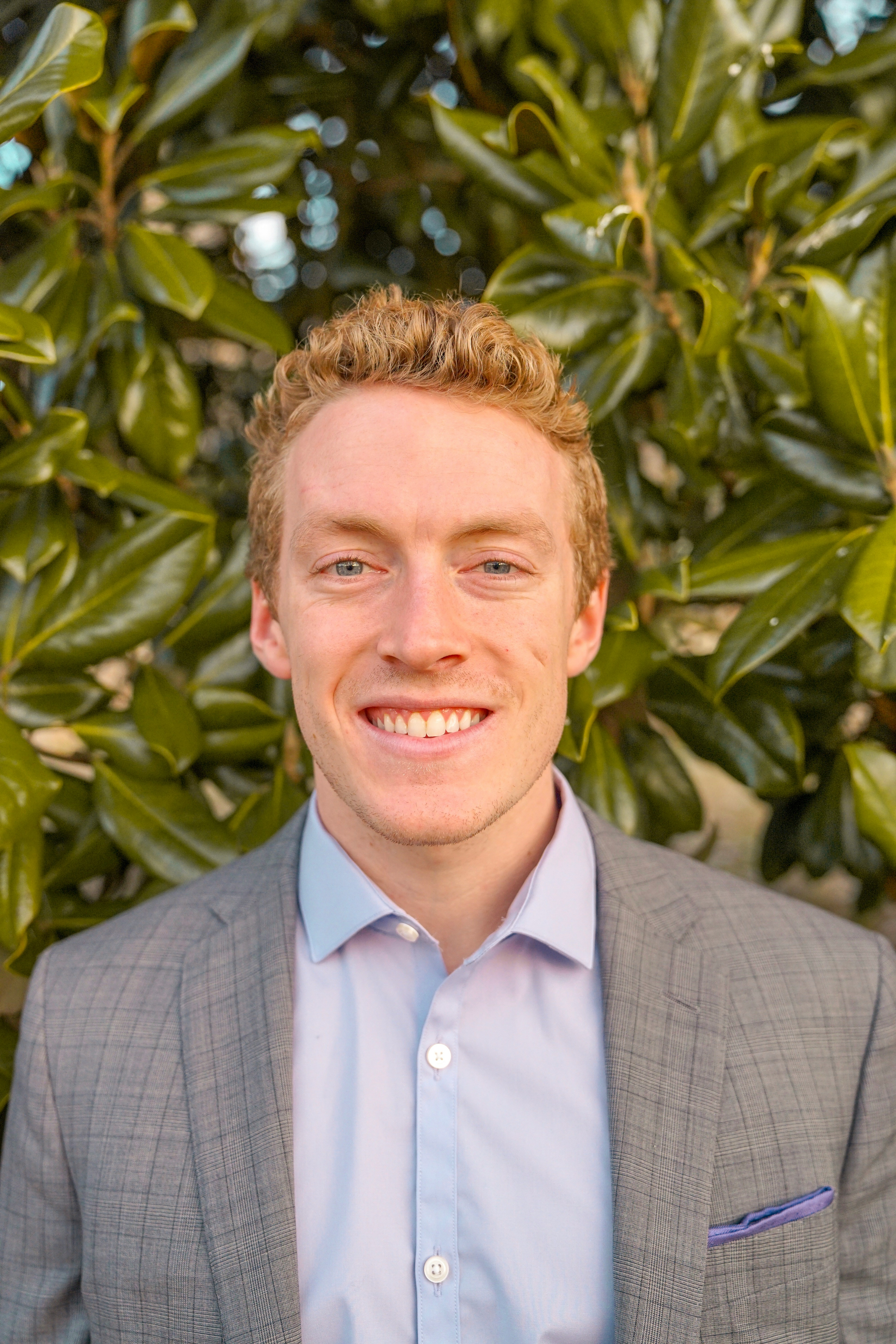 headshot of a smiling blonde man in business casual