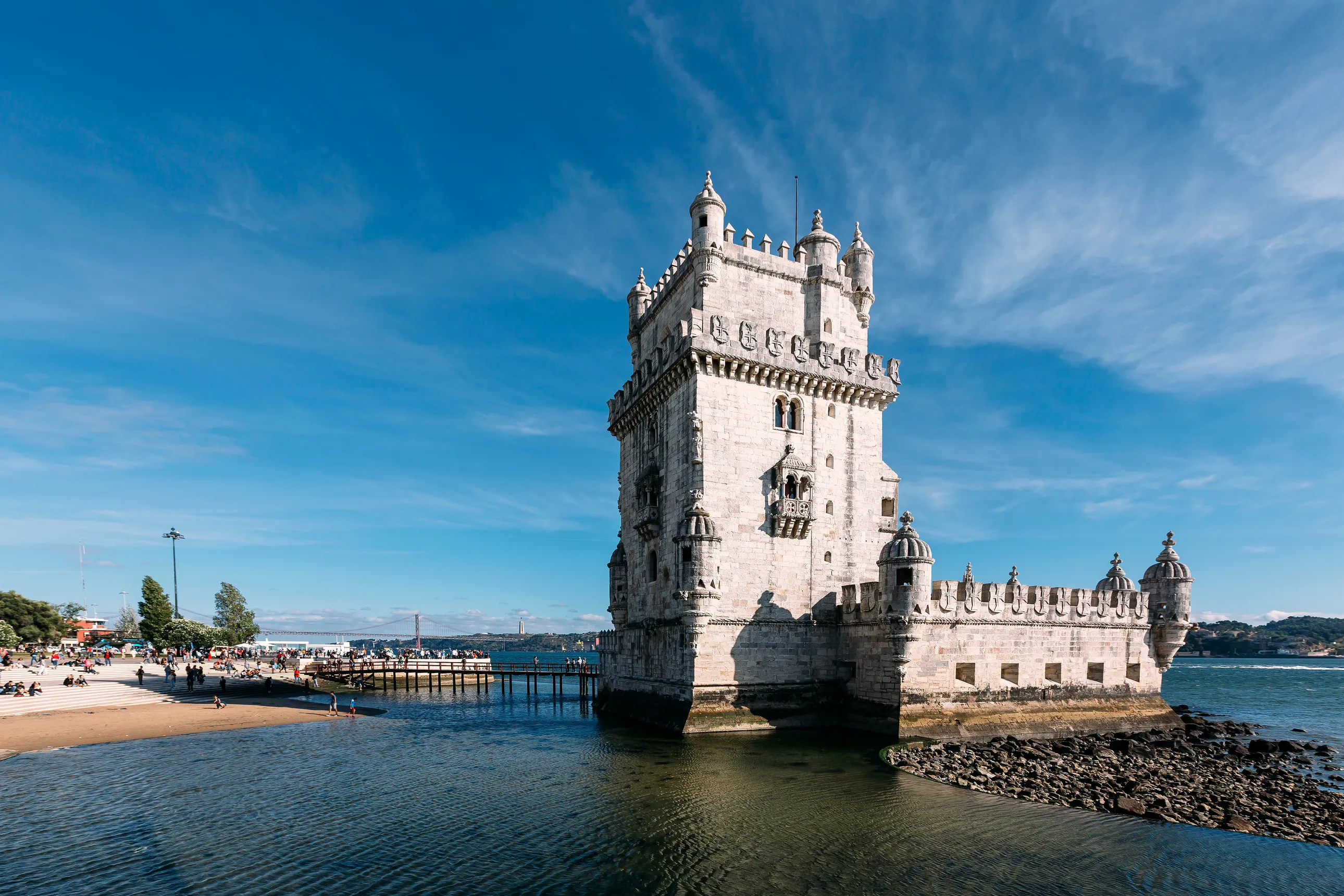 a stone tower on the shore surrounded by water