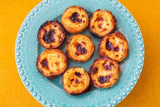 multiple pastries on a blue plate against a yellow background